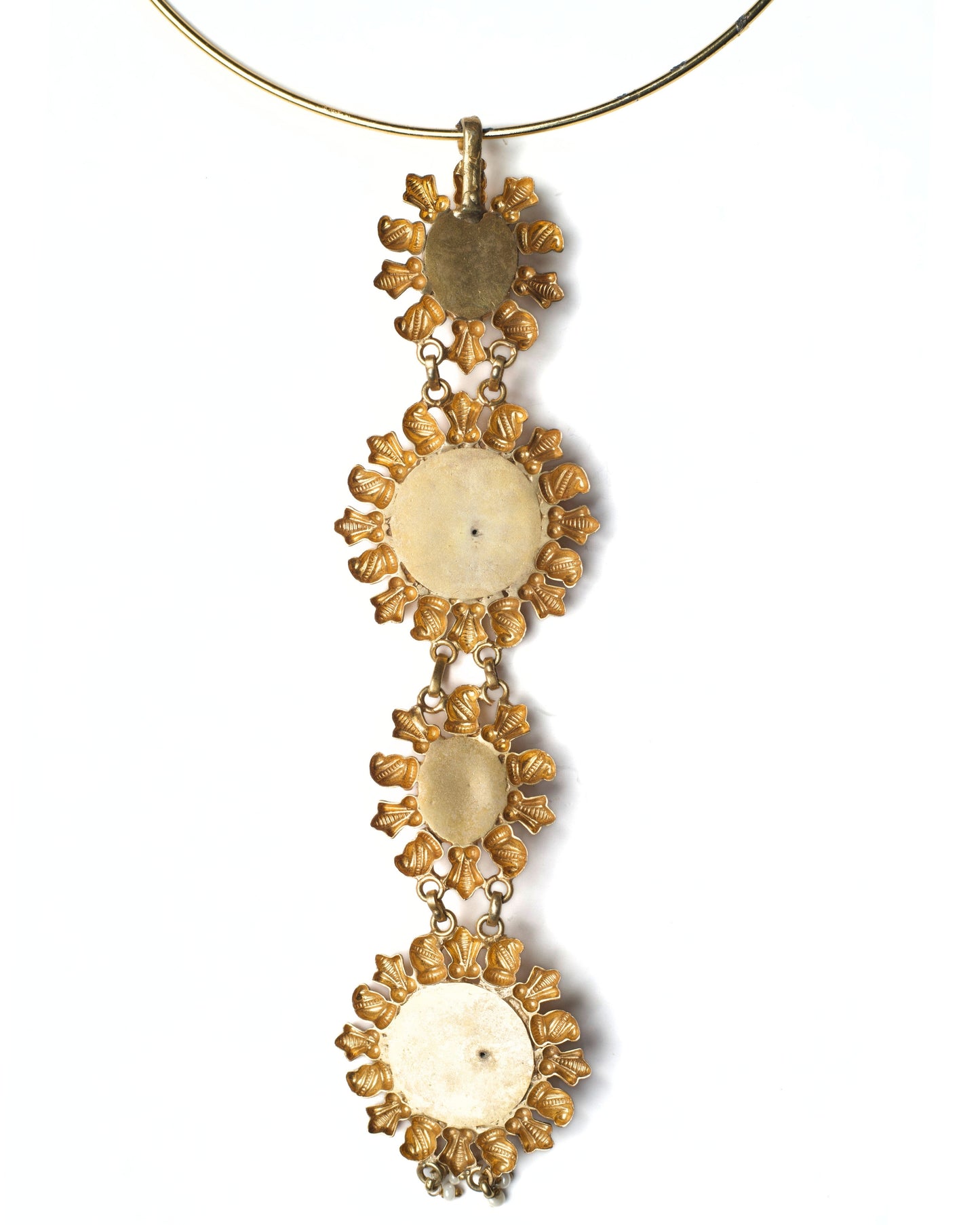 Back view of rigid gold-toned hasli showing smooth circular band and drop attachment