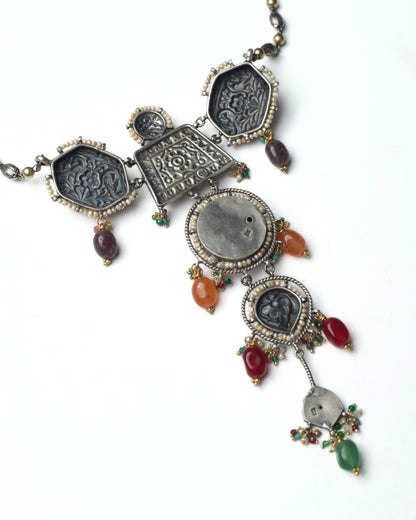 Back view of red stacked heirloom necklace choker in oxidised silver with kundan floral motifs, pearl borders, parrot details, and multicolour stone drops
