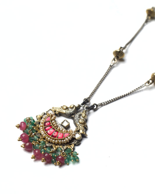Close-up of parrot motif and curved kundan stone arc with gemstone drops in silver necklace