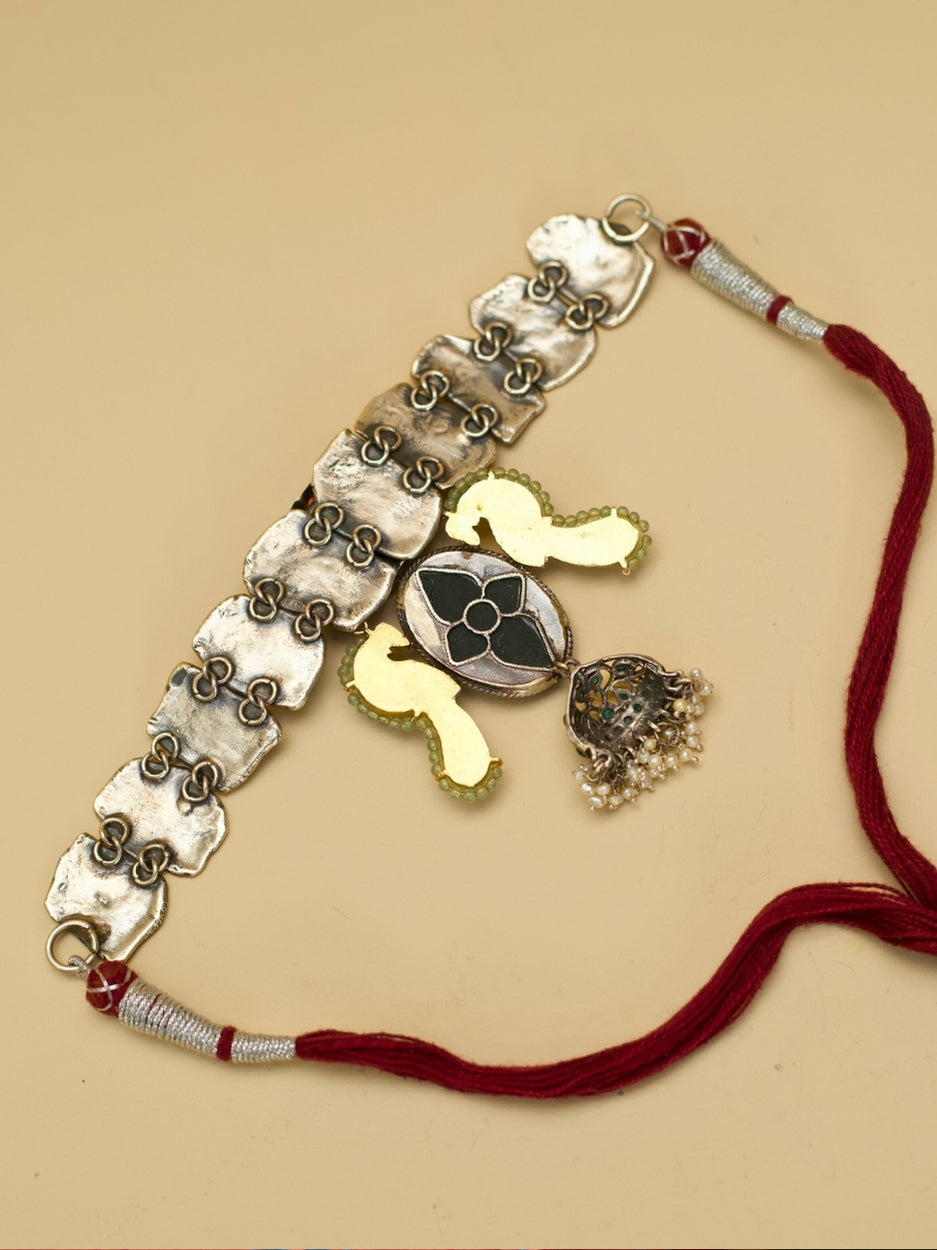 Close-up of Naksa's handcrafted Peacock Mirage Choker in 92.5 silver featuring lotus centrepiece, carved green stone, and kundan-set bird.