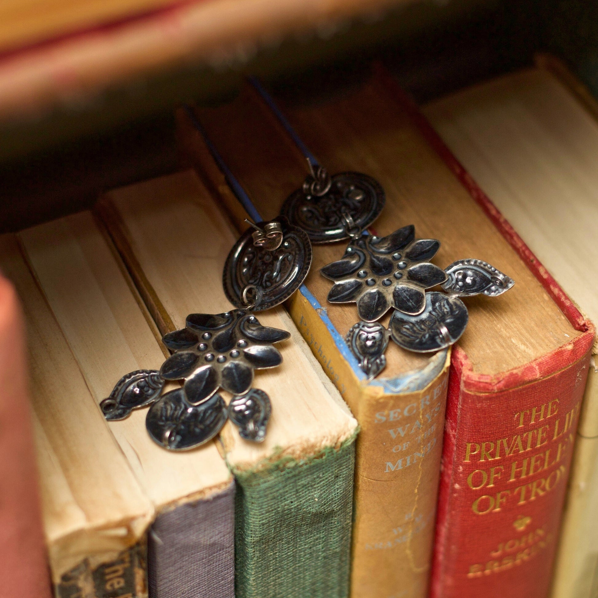 This extremely lightweight three-tier heritage silver earring features intricate flower embossing flanked by two carved fish. A perfect choice for everyday wear, this 925 pure oxidised silver earring sings the poetry of nature.