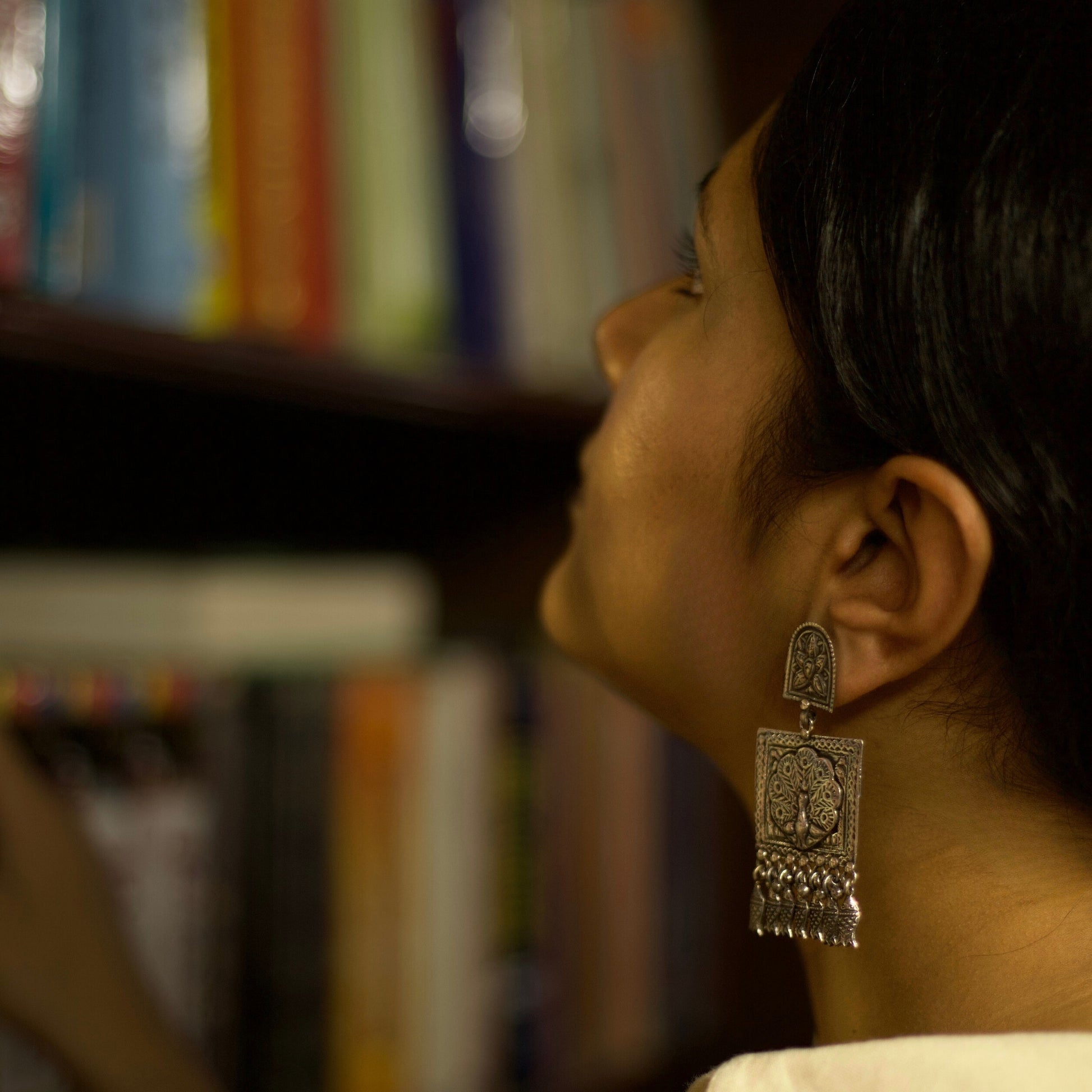Like the arched walkways and huge doors of the Indian palaces of myths, these heritage silver earrings feature intricate engravings giving them a regal look. The centrepiece features a peacock in all its glory and dangling fish charms to complete the royal look