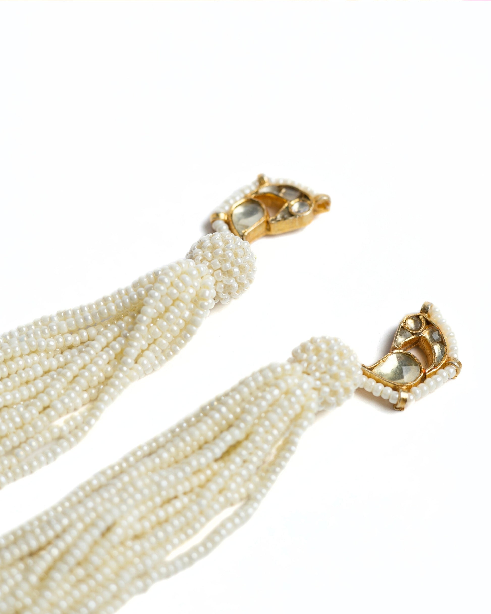Gold-toned 925 silver bird earrings with kundan-style stones and long cascading pearl tassels.
