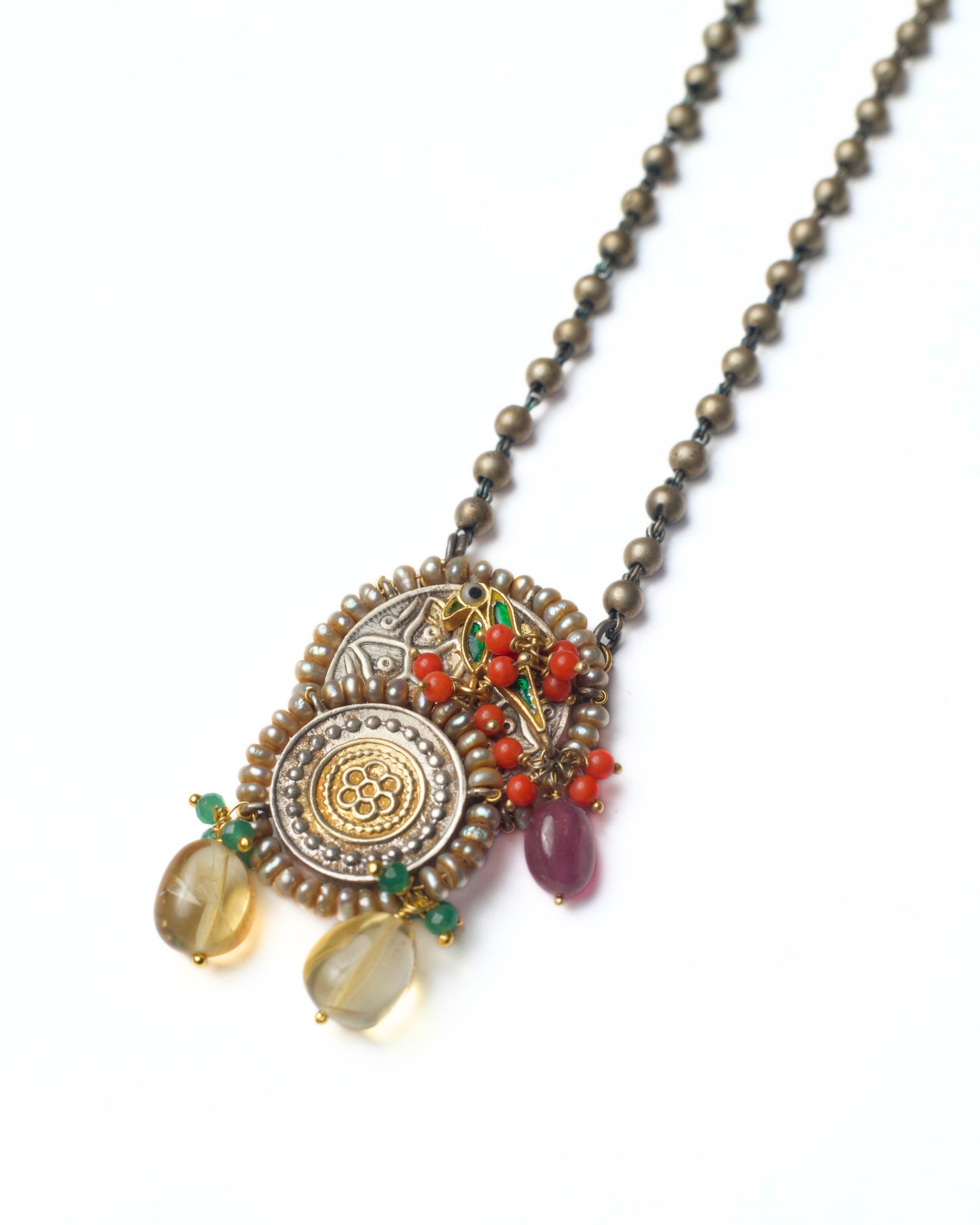 Rustwing Coin Necklace with stacked dual-tone coin pendants, bird motif, and orange stone drops on an antique silver chain