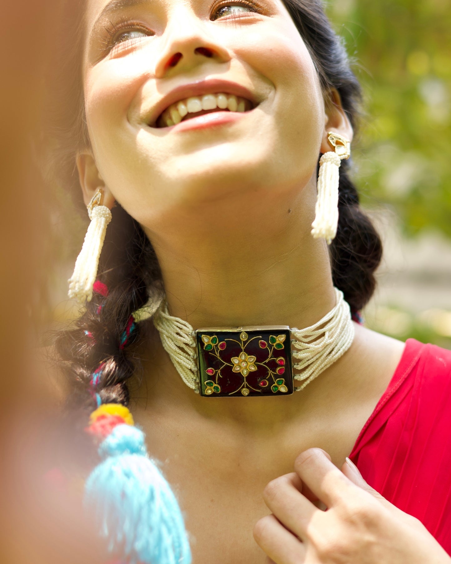 Black enamel floral choker in 925 silver with kundan-style stones, ruby and emerald accents, and multi-strand pearl detailing.
