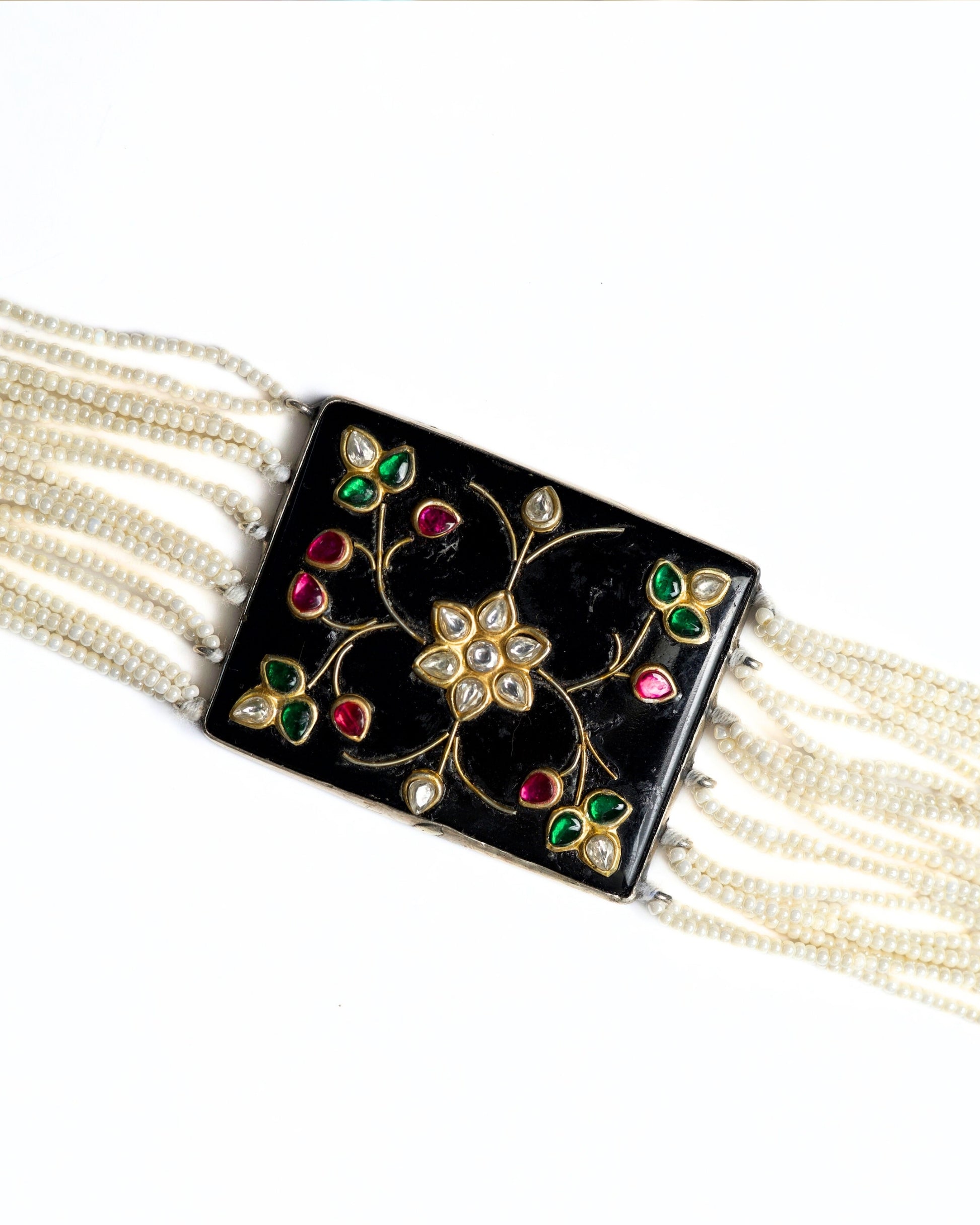 Black enamel floral choker in 925 silver with kundan-style stones, ruby and emerald accents, and multi-strand pearl detailing.