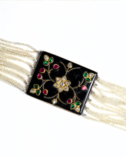 Black enamel floral choker in 925 silver with kundan-style stones, ruby and emerald accents, and multi-strand pearl detailing.