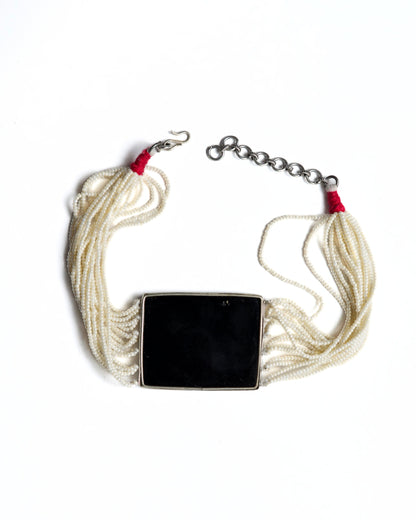 Black enamel floral choker in 925 silver with kundan-style stones, ruby and emerald accents, and multi-strand pearl detailing.