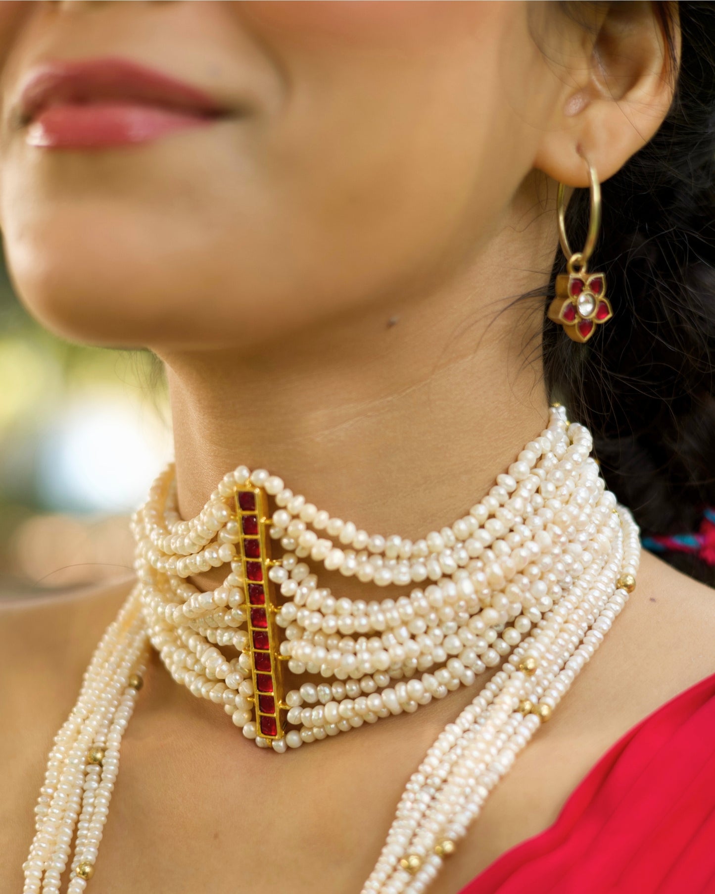 Multi-strand pearl choker in 925 silver featuring a vertical ruby-toned stone bar centre detail