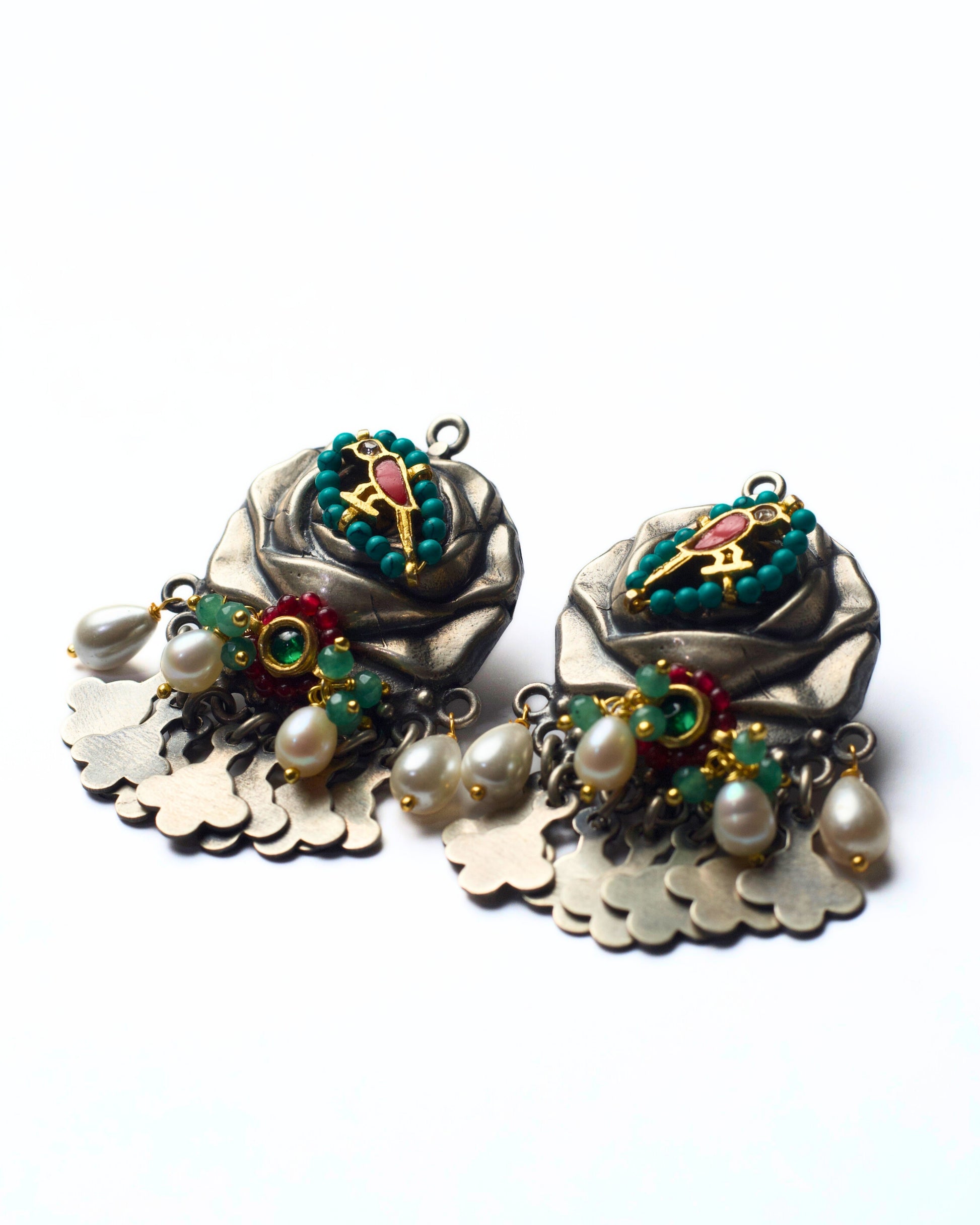 Side shot of handcrafted 925 silver fusion earrings with rose and bird motif, pearl accents, semi-precious stones, and silver fringe detailing