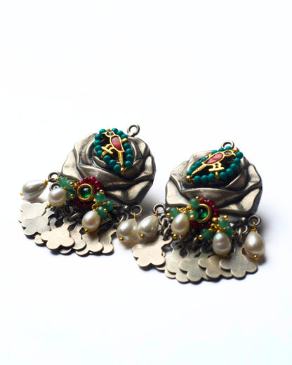 Side shot of handcrafted 925 silver fusion earrings with rose and bird motif, pearl accents, semi-precious stones, and silver fringe detailing