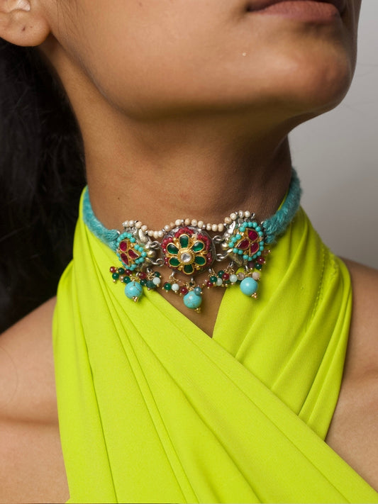 Close-up of a vibrant fusion choker in 92.5 silver with colorful floral enamel detailing, turquoise beads, and pearls on a soft aqua thread band.