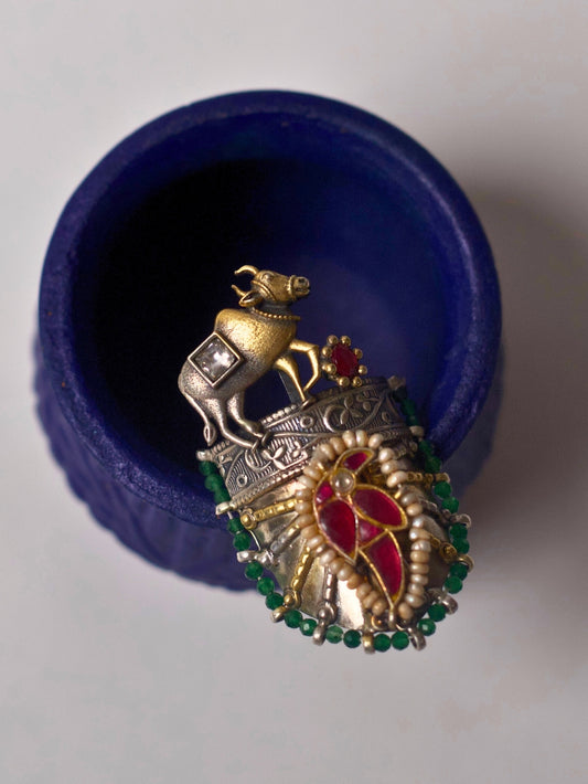 Close-up of handcrafted 92.5 silver ring with sculpted gold-tone bull, temple etching, red enamel leafwork, and green stone detail – Naksa Jewelry