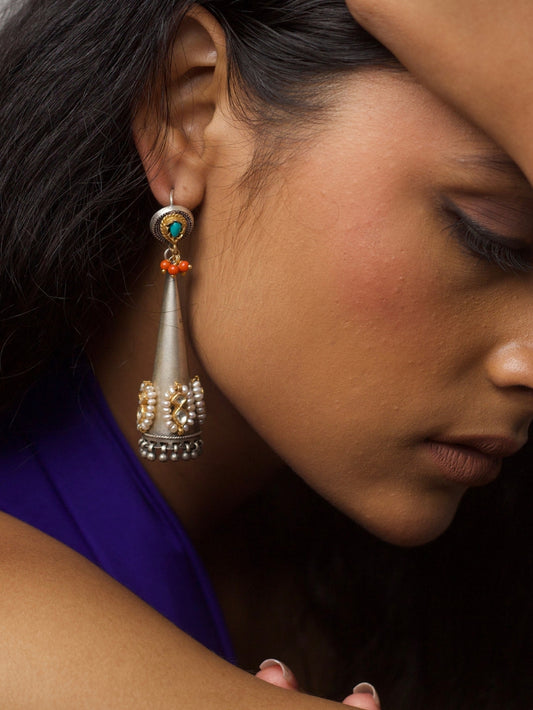 Close-up of The Rajnigandha Earrings – cone-shaped pure 92.5 silver earrings with pearls, turquoise stone top, and coral bead detailing.
