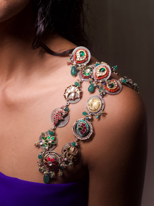The Maharani Medley Necklace Set in 92.5 silver featuring circular medallion forms, kundan stones, enamel detailing, moissanite accents, and matching earrings – styled on model in deep blue outfit.