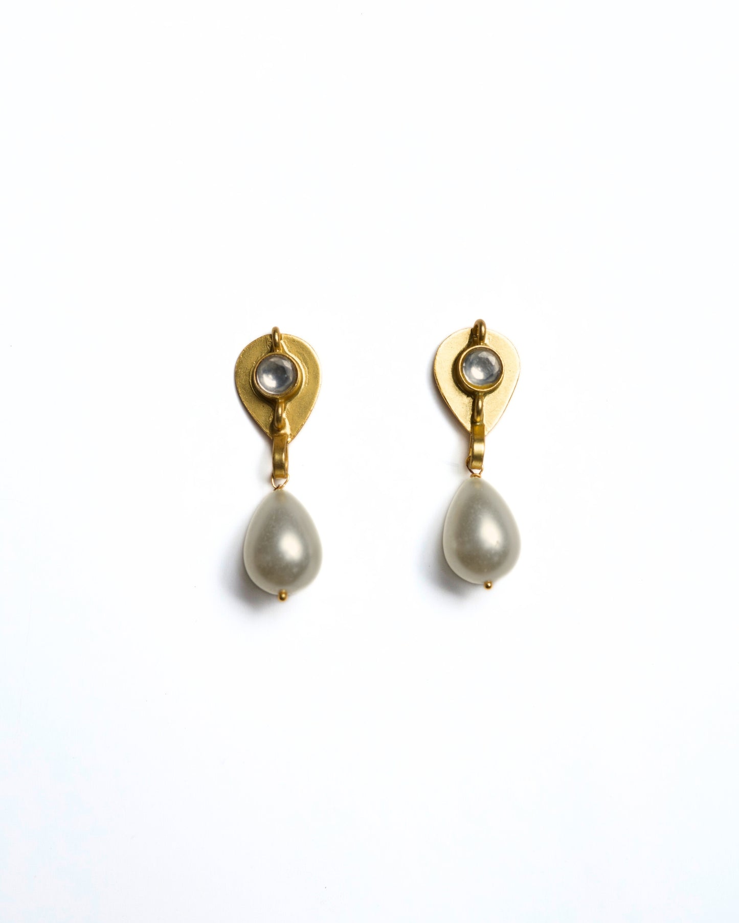 Close-up of gold-polished 925 silver drop earrings featuring a faceted clear stone stud and a suspended white teardrop pearl.